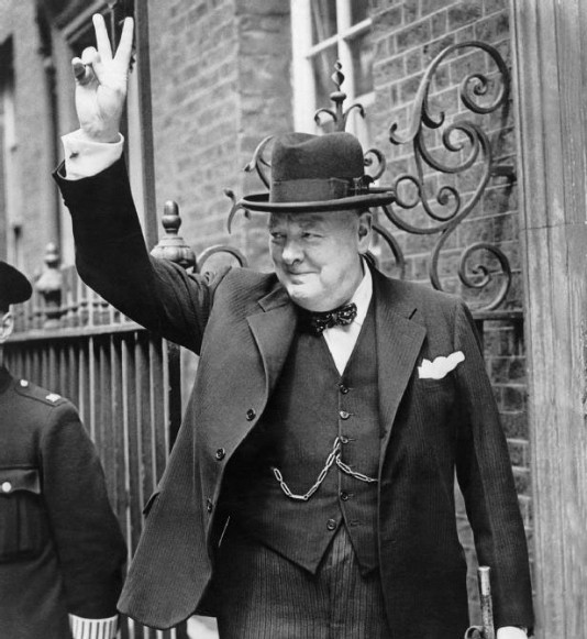 Churchill gives his famous "V for Victory" sign.
