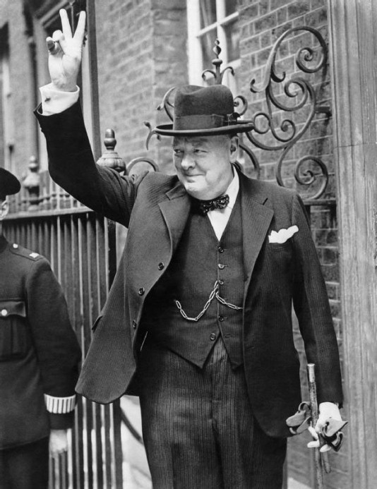 Churchill gives his famous "V for Victory" sign.