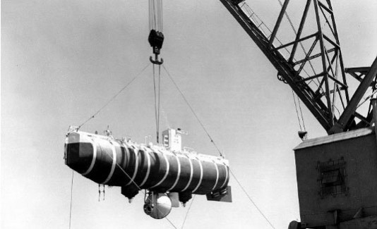 The bathyscaphe Trieste, hoisted above the water