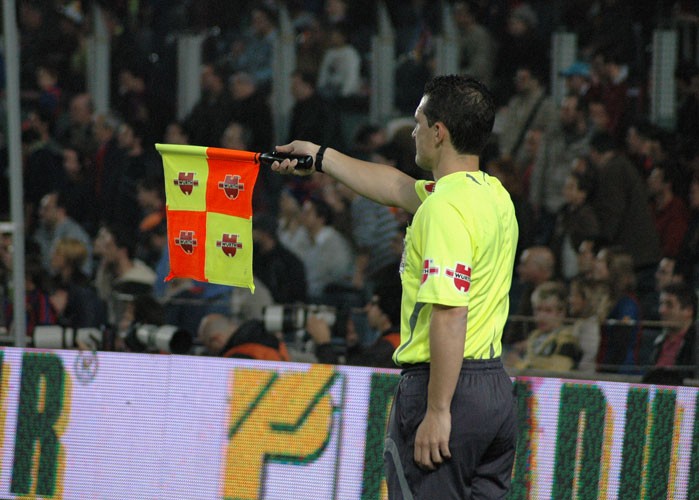 An assistant referee signalling offside