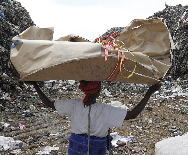 A woman carrying recyclable material at Dandora