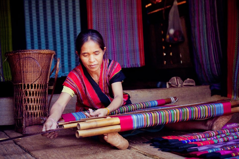 An Alak woman weaves cloth