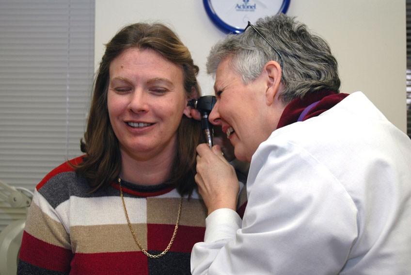 A doctor examines a patient’s ear