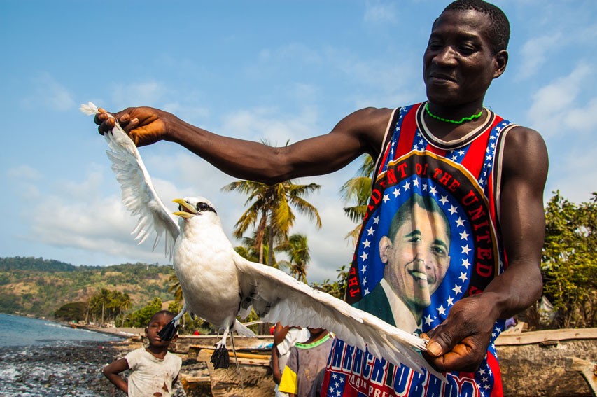 A São Toméan fisherman with a wild bird