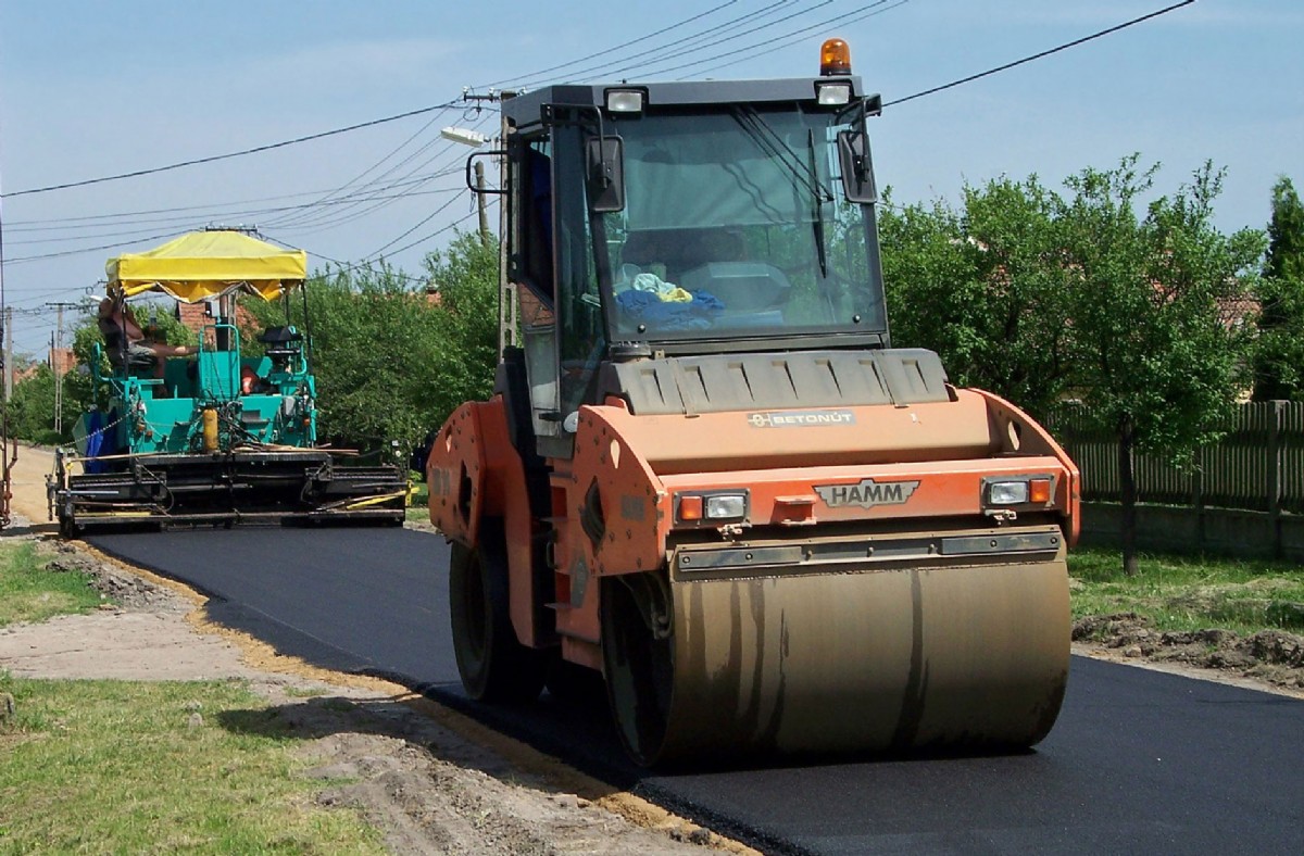 Asphalt layer being pressed flat by a roller