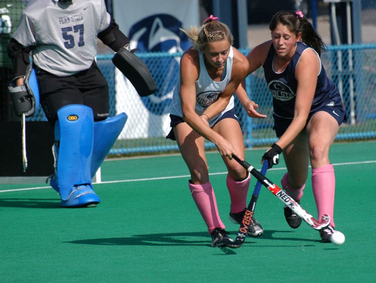 Players competing for the ball at hockey