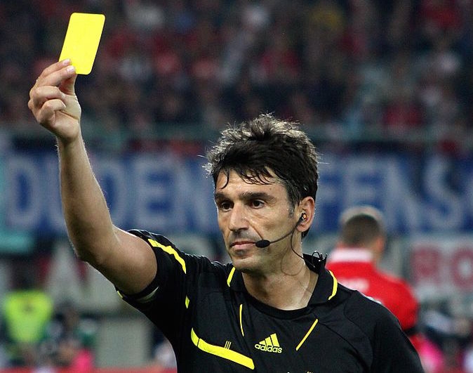 A referee shows a yellow card (Steindy)