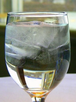 Ice floating in a glass of water
