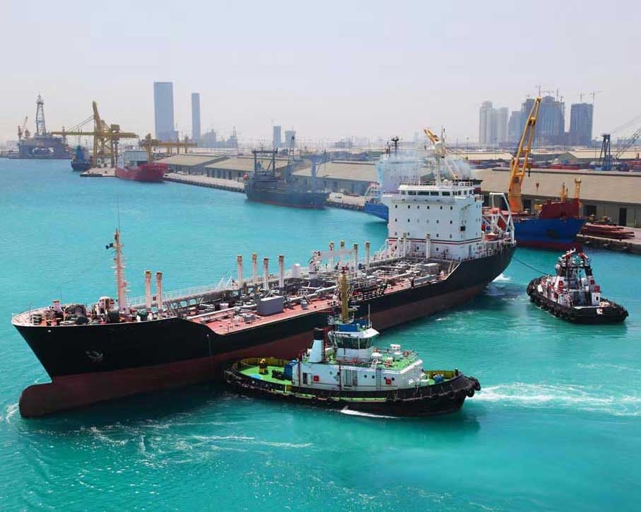 Tugs manoeuvre an oil tanker into port