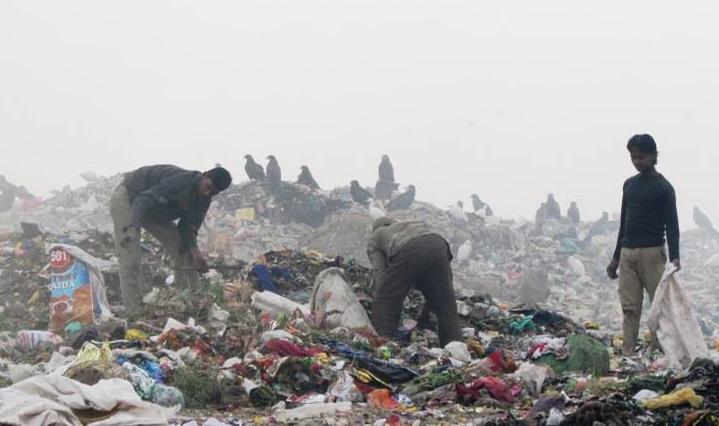 Workers on top of a landfill site at Ghazipur near Delhi, India