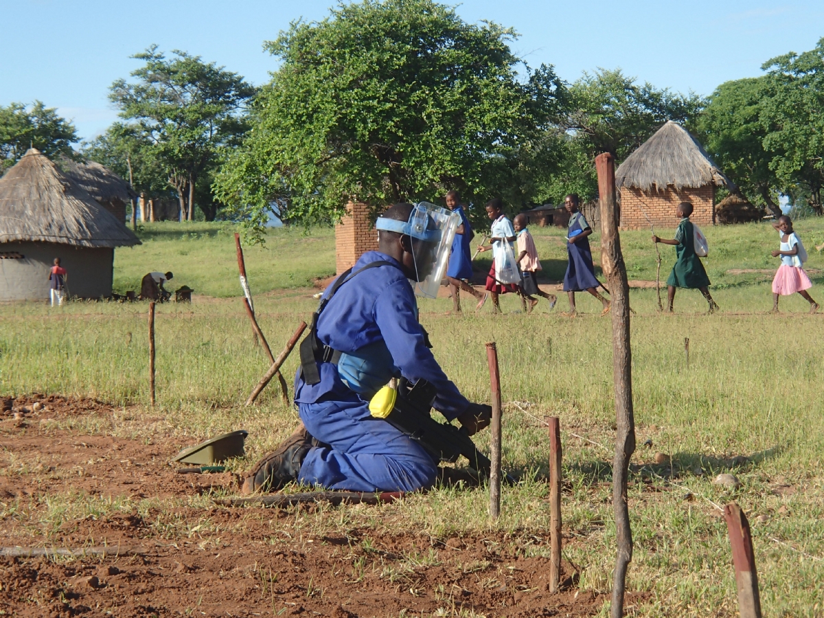 Zimbabwean children walk past a minefield