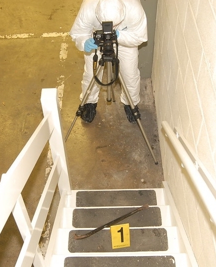 A forensic scene investigator photographing evidence