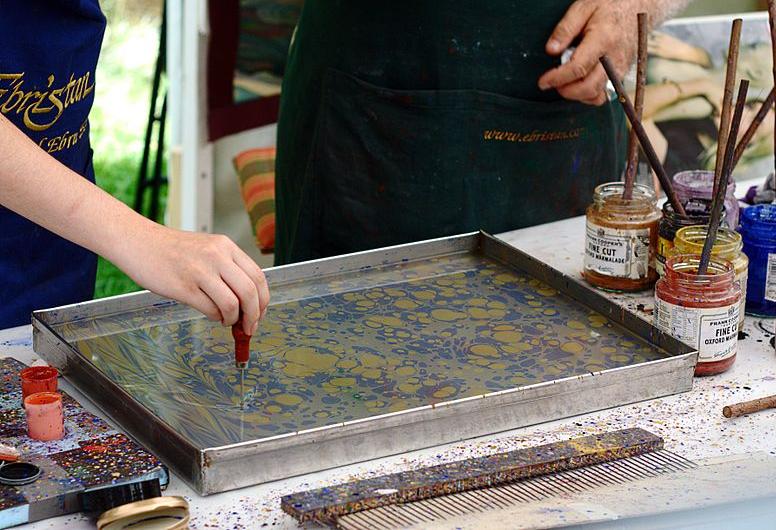 Preparing the inks in a tray of water for paper marbling
