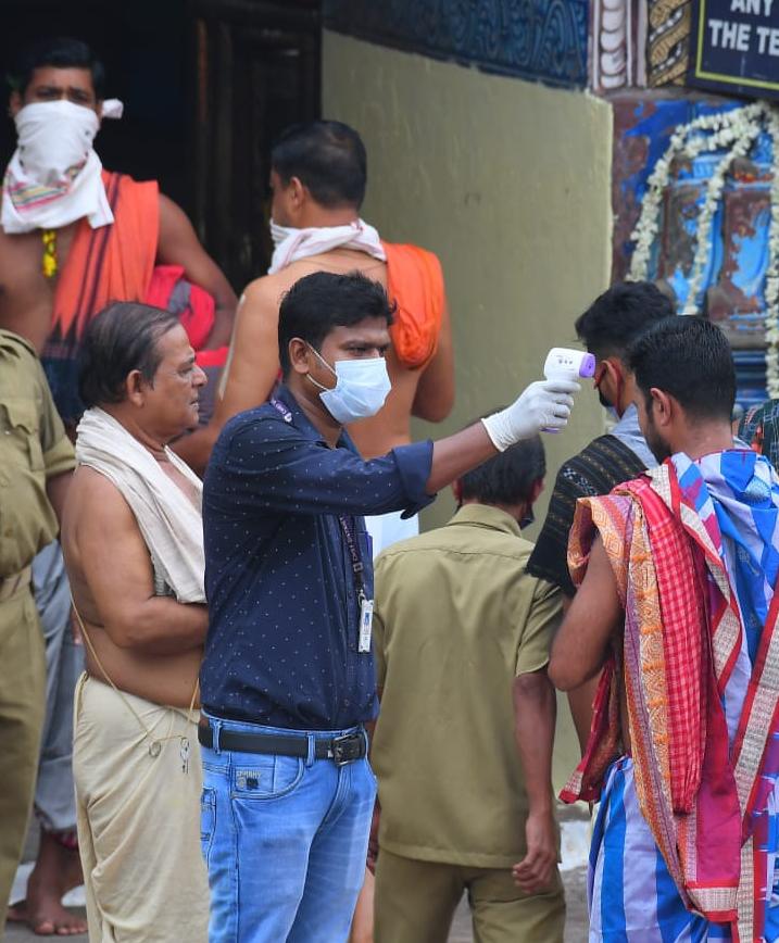Conducting temperature checks at a Hindu festival in India