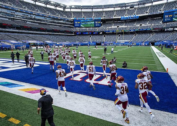 A football team runs out to an empty stadium, October 2020