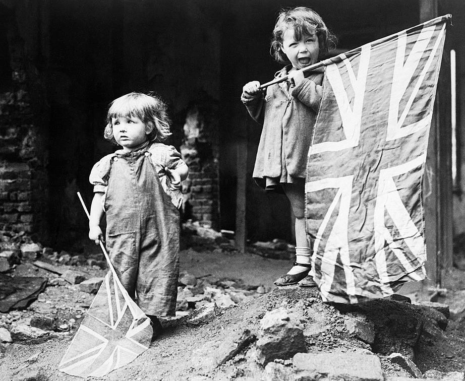 Two young children waving their flags on VE Day