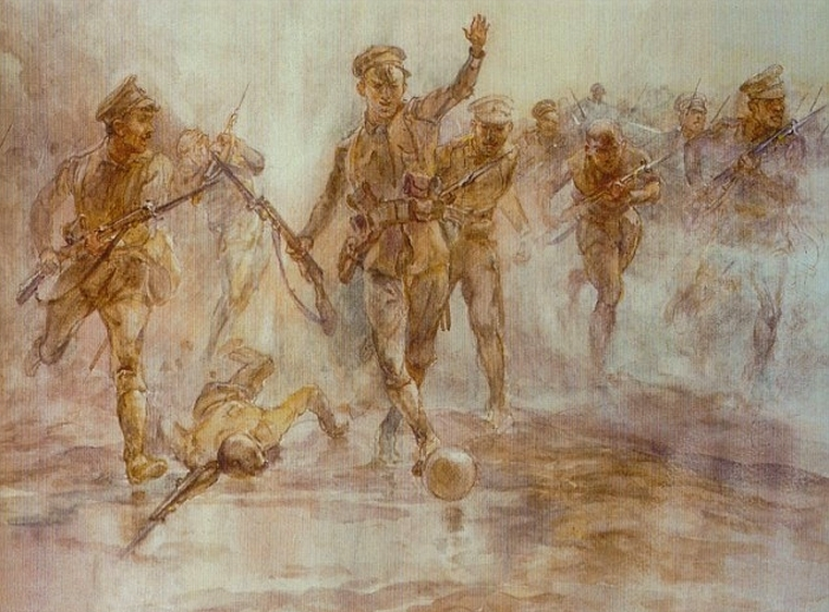 A soldier leads the charge at Loos while kicking a football