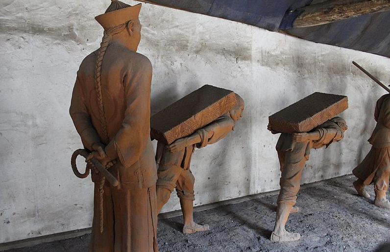 A sculpture showing slave labourers with their overseer in Qing China (1636 to 1912)