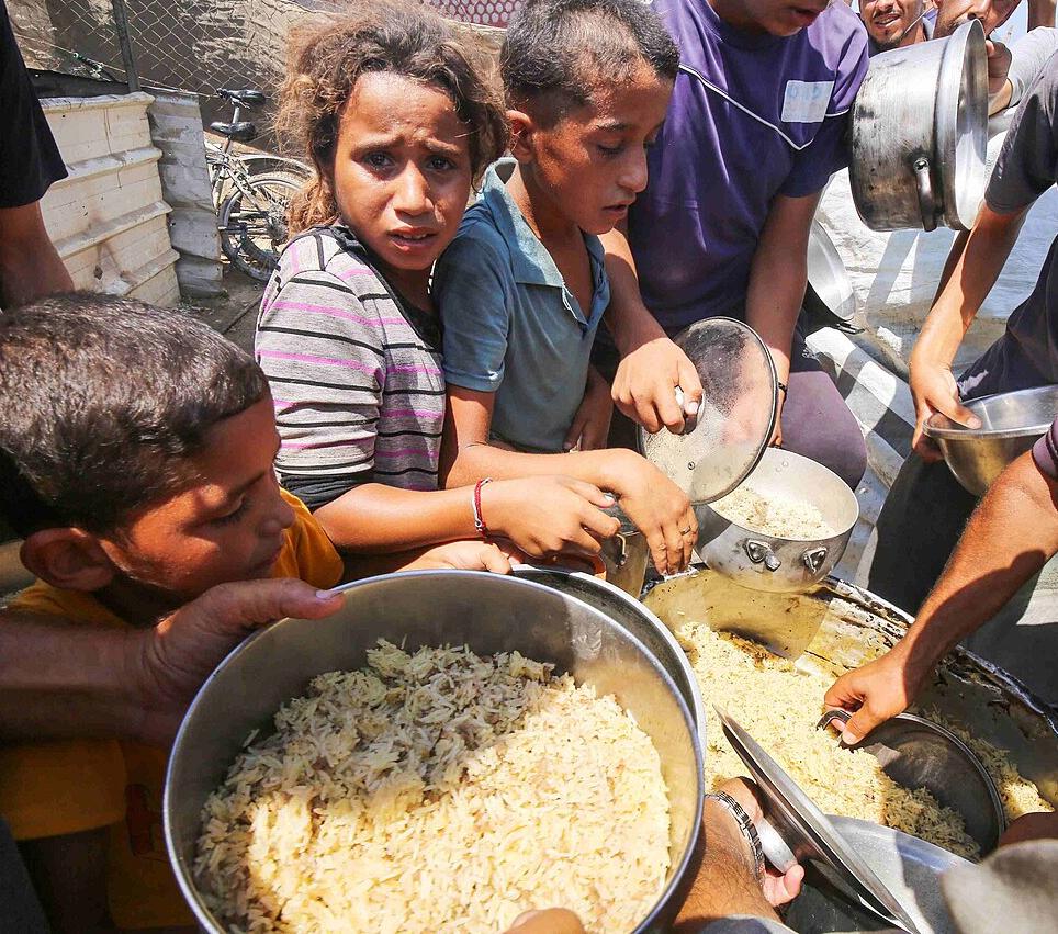 Palestinians in Deir el-Balah receiving food aid, August 2024