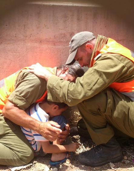 IDF officers shield a boy during a Hamas rocket attack, 2014