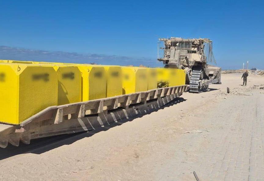 Israeli vehicles carrying concrete markers for the Yellow Line