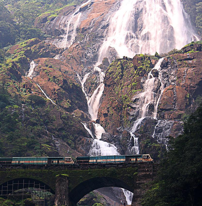 A train passes in front of the Dudhsagar Falls