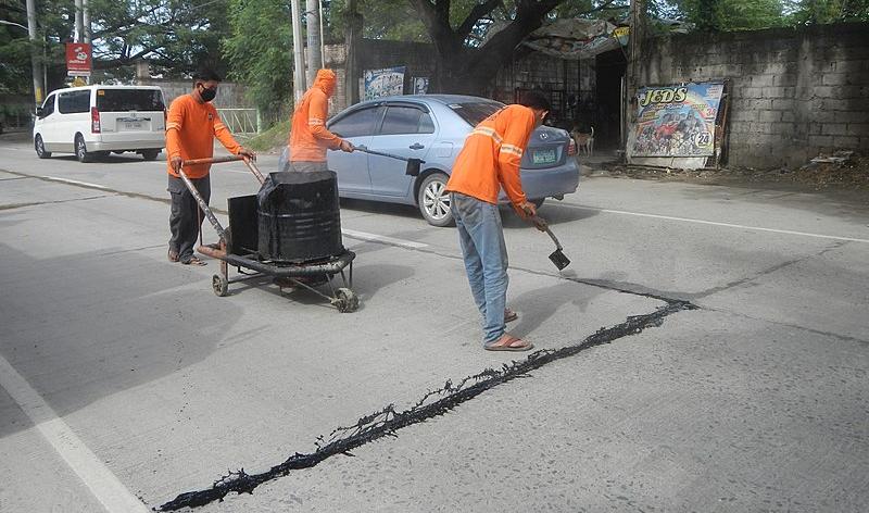 Bitumen (asphalt) in a hot mix with concrete is used to repair a road