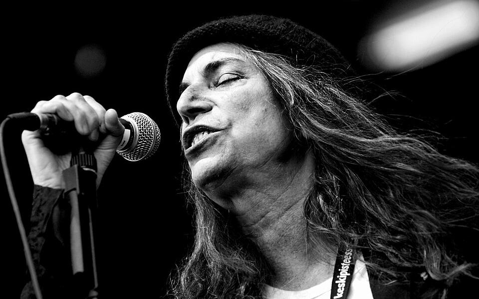 American rock singer and poet, Patti Smith, singing into a dynamic microphone