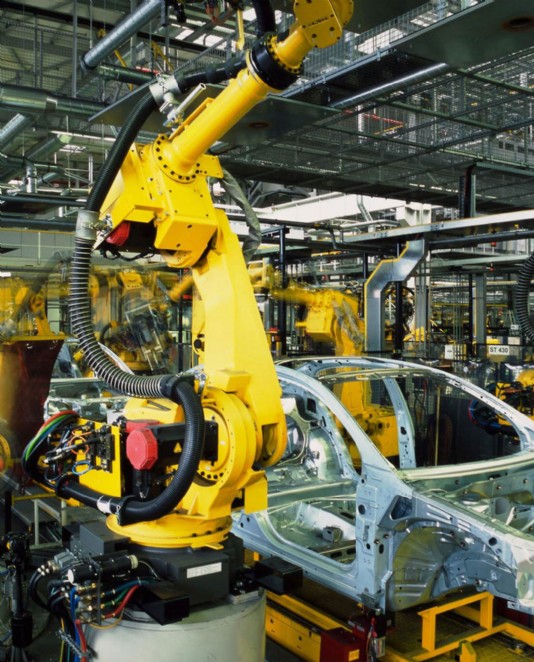 Robots build cars in a factory