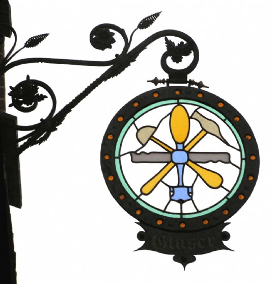 A guild sign outside the workshop of a glassworker